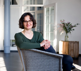 Rabea Wienholt sitzt freundlich blickend in einem Korbsessel